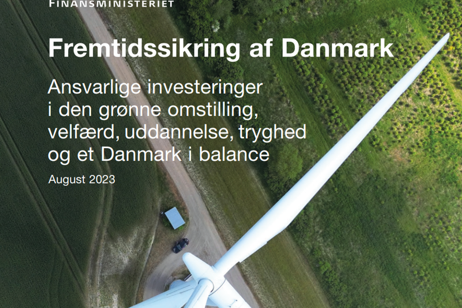 vindmølle med grønt landskab i baggrunden. I for grunden står der 