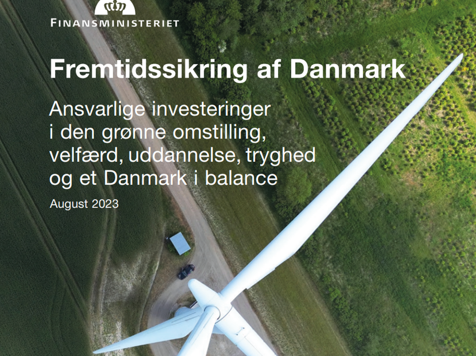 vindmølle med grønt landskab i baggrunden. I for grunden står der 