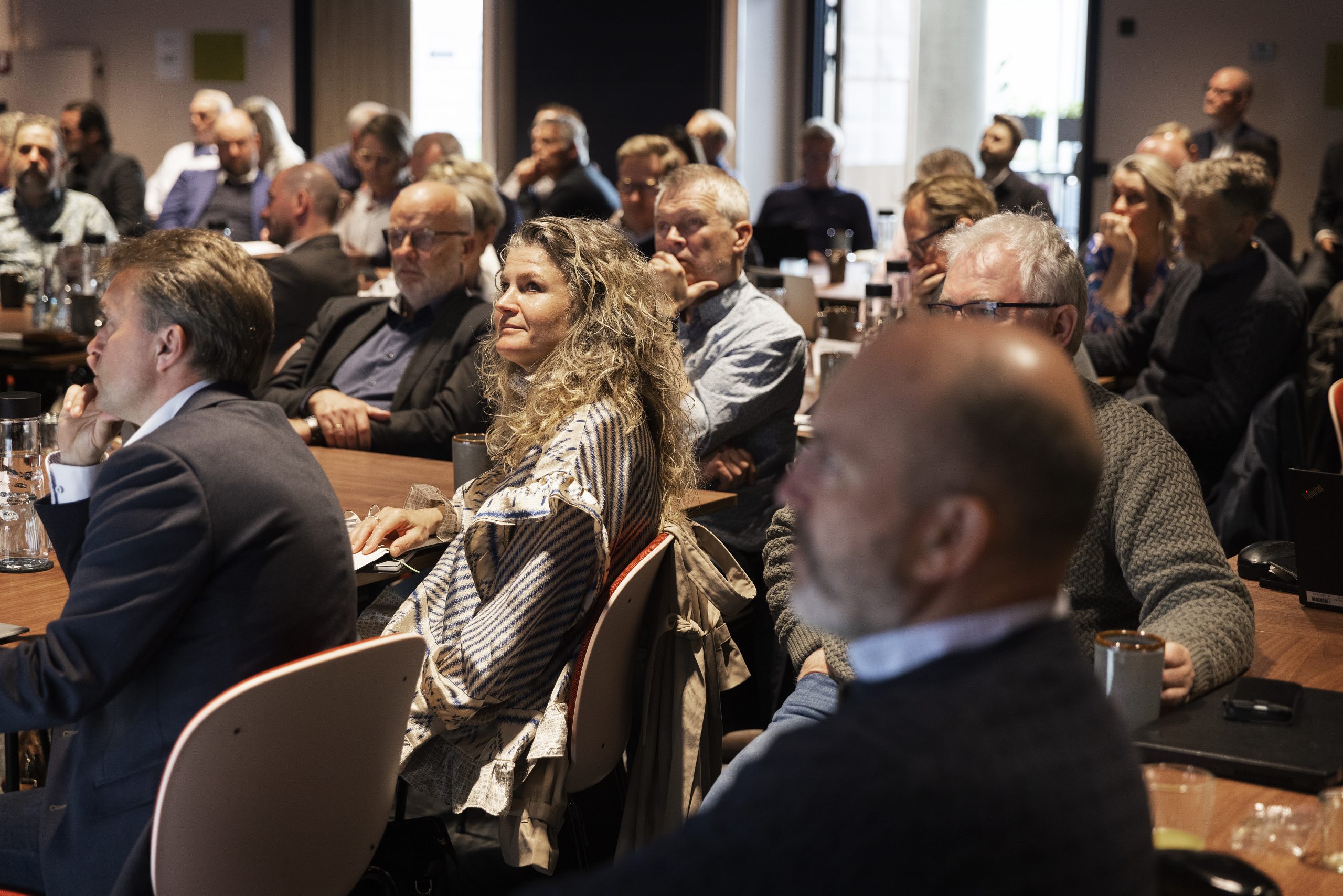 lokale med folk ved borde til Skolelederforeningen konference